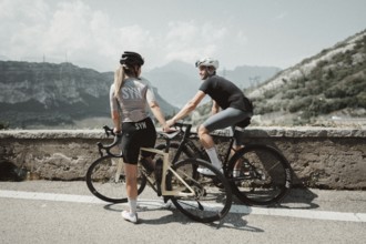 Woman and man cycling on Lake Garda in Italy. Sunny weather and dolce vita
