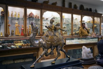 Prince and princess on a silver and gold foil camel in a shop in the old city centre, Jaipur,