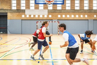 Basketball players running and practicing in a gymnasium, showcasing teamwork and skill during an