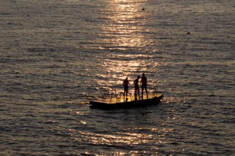 Children playing on bathing island, bathing raft, swimming island, Étretat, sea, sunset, evening