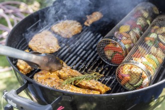 Barbecue in the garden. Meat and vegetables, vegetarian and vegan, are served on the kettle grill.