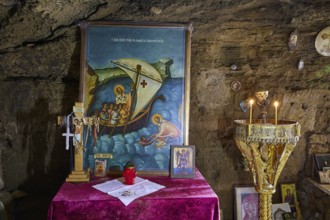 Altar with a painting of a biblical sea voyage, decorated with crosses and glowing candles, chapel,