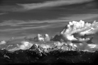 Clouds drift over the striking peaks of the Swiss mountains, showcasing a breathtaking view near