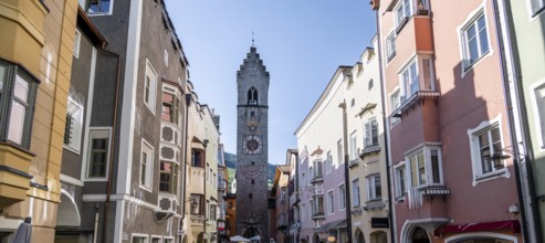 Old town, colourful houses in the main street, Zwölferturm tower at the back, old town, Sterzing,