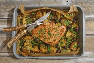 Juicy roasted turkey breast is beautifully presented on a tray with golden, seasoned potatoes and