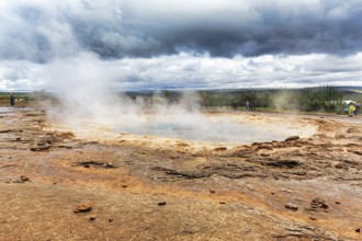Steaming Strokkur, tourists waiting for eruption, high temperature area Haukadalur, tourist