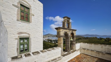 Bell tower on the roof of a white building overlooking the sea, Monastery of the Revelation, Moni