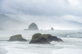 A rugged coastal landscape with rocks in the sea and a cloudy sky, Indian Beach, Oregon, USA, North