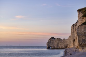 People on the beach, pebble beach, rock arch Falaise or Porte d'Amont, Étretat, sea, steep coast,