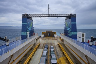 Ferry with parked cars and view of the sea under a cloudy sky, summer, Cook Strait, North Island,