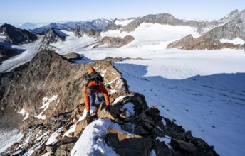 Mountaineer climbing on a rocky ridge on the mountain peak Wilder Freiger, in the background Signal