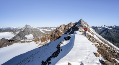 Mountaineer on rocky ridge with snow, mountain peaks Wilder Freiger and Wilder Pfaff in the