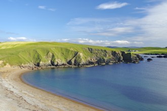 Green hills hug a sandy coastline with calm blue waters and wide open skies, Hillswick, Eshaness,