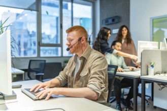 Focused call center agent providing customer support, typing on keyboard while wearing headset in
