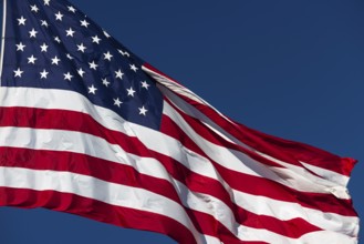 American flag waving in the wind against deep blue sky