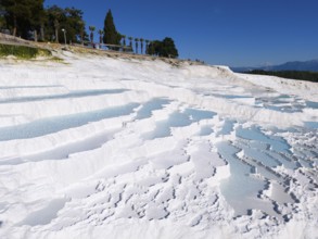 Cascading white terraces with turquoise water against a blue sky, aerial view, sinter terraces,