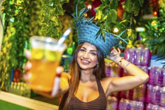 Smiling bartender wearing a straw hat offering a refreshing tropical cocktail at a vibrant tiki