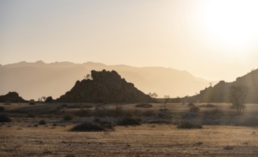 Desert landscape in the evening light at sunset, barren landscape with hills of stacked rocks,