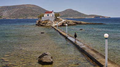 Person walking on jetty to chapel in calm blue sea under clear sky, chapel, church, Agios Isidoros,