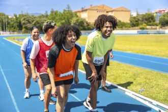 Group of athletes catching their breath and recovering after completing a race on a vibrant blue