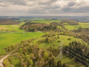 Wide fields crossed by power lines under a cloudy sky, Glems reservoir, Swabian Alb, Germany