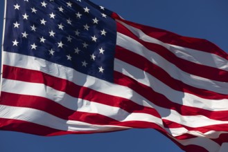 American flag waving in the wind against deep blue sky