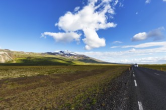 Tarmac road through barren volcanic landscape with a view of the snow-covered Snæfellsjökull