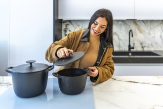 Smiling woman selecting a cooking pot in a bright home improvement store's kitchenware department,