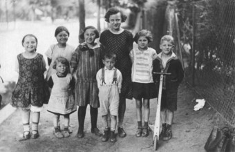 Boys and girls on the pavement, 1920s, group of children posing laughing on a rural road,