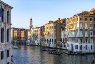 View of the Grand Canal with gondoliers at sunset, picturesque evening mood with palazzos on the