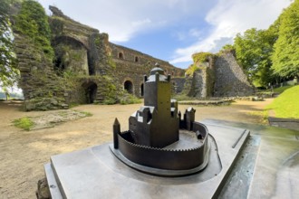 In front small metal model of the original fortress building of the ruins of the imperial palace of
