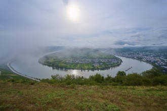 River bend under fog and with soft sunlight in the morning, surrounded by hills, summer, Rhine bend