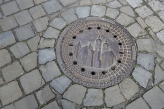 Manhole cover with cathedral as landmark, cobblestones, floor, inscription, cathedral square,