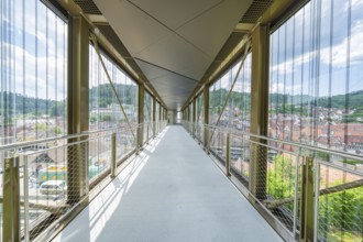 A modern, light-flooded glass corridor with a view of the urban surroundings, Zob extension with