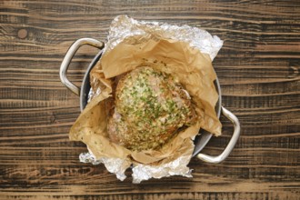A perfectly roasted turkey thigh, seasoned with herbs and spices, rests on a bed of parchment paper
