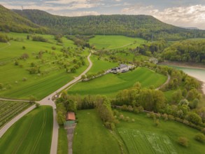Green landscape with meadows and fields around a building on a hill, Glems reservoir, Swabian Alb,