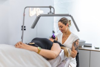 Beautician performing a permanent makeup treatment on a client's face, using a specialized device
