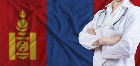 Doctor with crossed arms on Mongolia flag. Mongolia health and care concept. Female doctor on