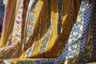 Various decorative fabrics with floral patterns in yellow and blue, typical of Provence, France