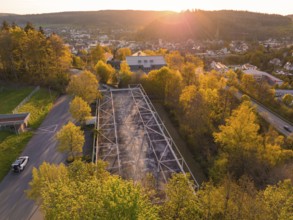 Aerial view of an empty car park at sunset, surrounded by trees and roads, Nagold, district of