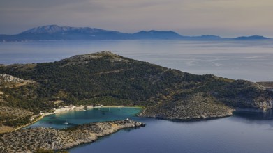 Coastal landscape with hills and blue water under a clear sky, Holy Week, Panormitis Bay,