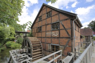 Grinding mill with brick building and water wheel, mill wheel, wooden construction, inscription,