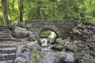 An old, small stone bridge over the Brühlbach, wild and romantic stream and source of the Urach