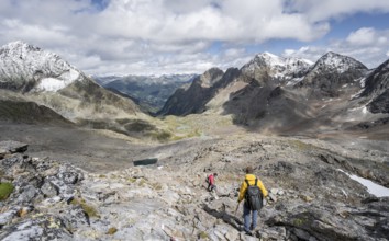 Two mountaineers in a rocky mountain landscape, descending from the summit of Keeskopf, behind them