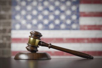 American flag on wall behind gavel resting on table