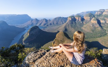 Hiker enjoying sunset at Blyde River Canyon with Three Rondawels peak, view of canyon with Blyde