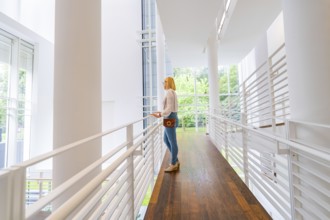 A woman stands in a modern, light-flooded interior with a wooden floor, Frieder Burda Museum, Baden