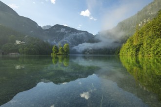 Mystical morning at Königssee in Schönau with boathouses and Christlieger. Sunrise and beautiful