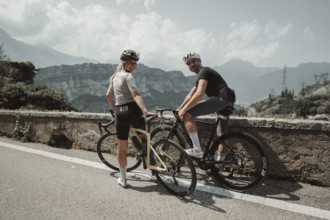Woman and man cycling on Lake Garda in Italy. Sunny weather and dolce vita