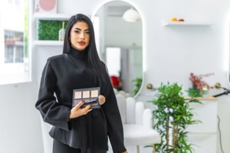 Professional makeup artist holding a palette and brush, offering makeup services in a modern and